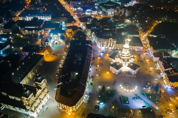 Luftaufnahme von hell beleuchteten Straßen und Gebäuden im ukrainischen Stadtzentrum von Ivano-Frankivsk bei Nacht.