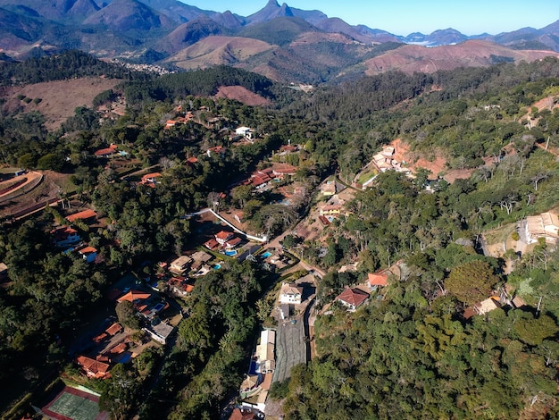 Luftaufnahme von Itaipava, Petrópolis. Berge mit blauem Himmel und einigen Wolken rund um Petrópolis, Bergregion von Rio de Janeiro, Brasilien. Drohnenfoto. Sonniger Tag.