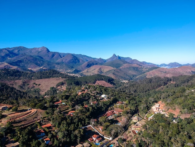 Luftaufnahme von Itaipava, Petrópolis. Berge mit blauem Himmel und einigen Wolken rund um Petrópolis, Bergregion von Rio de Janeiro, Brasilien. Drohnenfoto. Sonniger Tag.