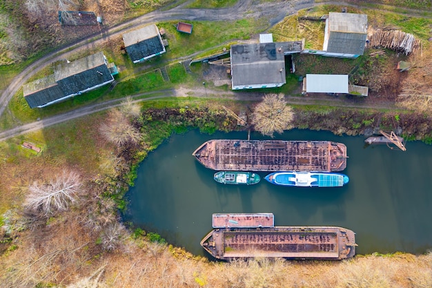 Luftaufnahme von Ladekränen und Frachtschiff am Flussufer im Wald Lastkähne und Kräne stehen am Flusshafen Gewinnung von Sand aus dem Fluss