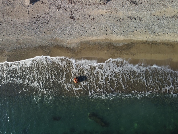 Luftaufnahme von oben auf ruhigem azurblauem Meer und vulkanischen Felsküsten kleine Wellen auf der Wasseroberfläche in