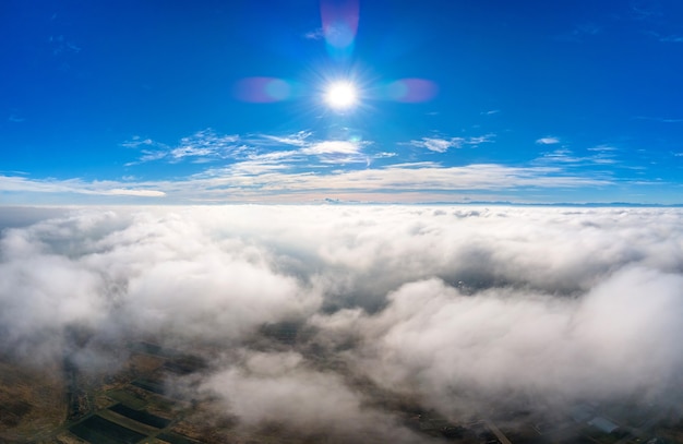 Luftaufnahme von oben auf weiße geschwollene Wolken an einem sonnigen Tag.