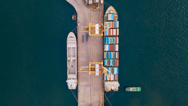 Luftaufnahme von oben. Containerschiff im Pier mit Kranbrücke führt Import- und Exportgeschäfte auf offener See durch.