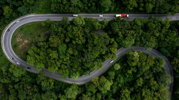 Luftaufnahme von oben Großer Frachttransporter-Sattelschlepper auf der Autobahn Straße LKW fährt auf Asphaltstraße grüner Wald Fracht-Sattelauflieger bewegt sich auf der Straße