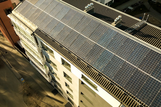 Luftaufnahme von photovoltaik-solarzellen auf dem dach eines wohnblocks zur erzeugung sauberer elektrischer energie. autonomes wohnkonzept.
