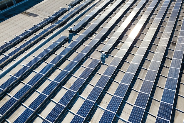 Luftaufnahme von Photovoltaik-Sonnenkollektoren, die vom Dach des Industriegebäudes montiert werden