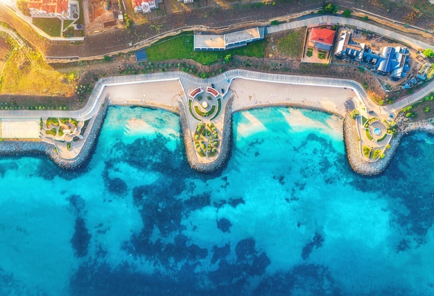 Luftaufnahme von Restaurants am blauen Meer des Sandstrandes bei Sonnenuntergang