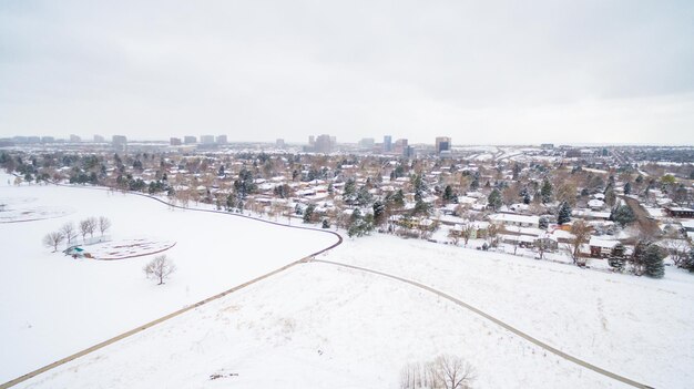 Luftaufnahme von Schulsportplätzen und Wohngebiet im Winter.