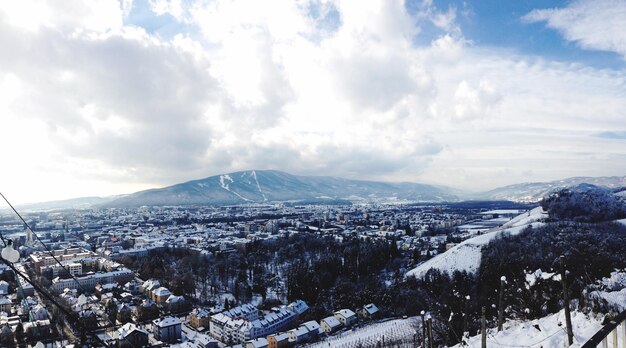 Foto luftaufnahme von stadtlandschaften und schneebedeckten bergen gegen den himmel