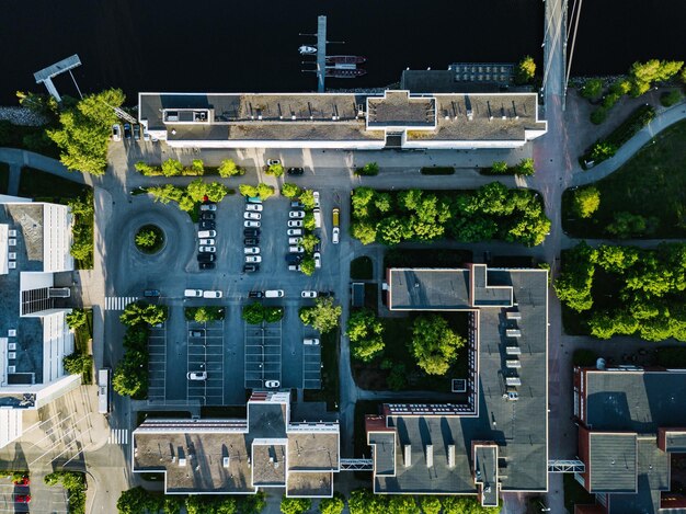 Luftaufnahme von städtischen Gebäuden mit Parkplätzen und der Universität Jyväskylä am See in Finnland