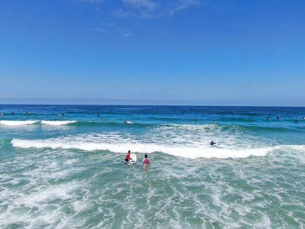 Luftaufnahme von Surfern, die auf die Wellen im blauen Wasser La Jolla, Kalifornien, USA, warten und paddeln