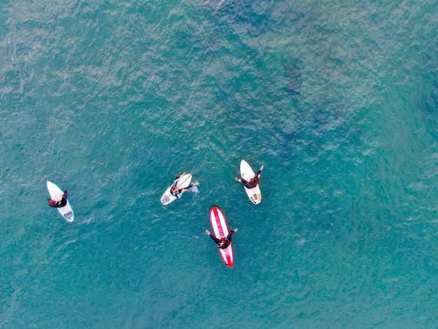 Luftaufnahme von Surfern, die auf die Wellen im blauen Wasser warten. Del Mar Beach, Kalifornien, USA.