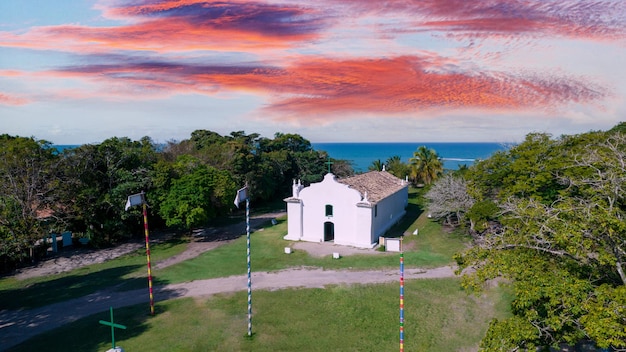 Luftaufnahme von Trancoso Porto Seguro Bahia Brasilien Kleine Kapelle im historischen Zentrum von Trancoso namens Quadrado mit dem Meer im Hintergrund