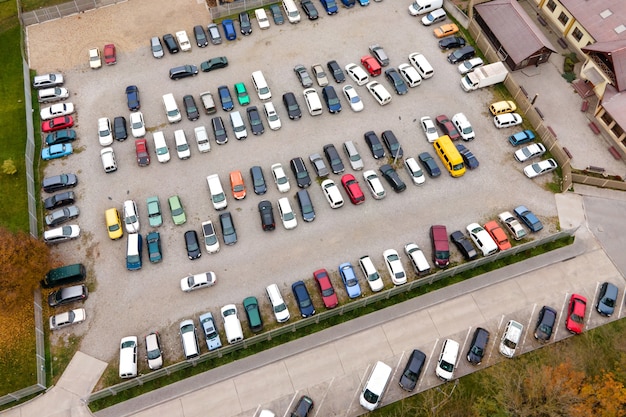 Luftaufnahme von vielen bunten Autos, die auf einem öffentlichen Parkplatz geparkt sind.