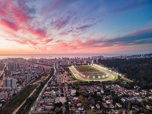 Luftaufnahme von Vina del Mar bei farbenfrohem Sonnenuntergang mit einem Fluss und einer Rennbahn race