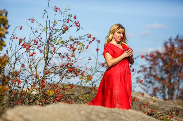 Luftbild auf Mädchen in rotem Kleid auf Felsen oder Beton ruiniert