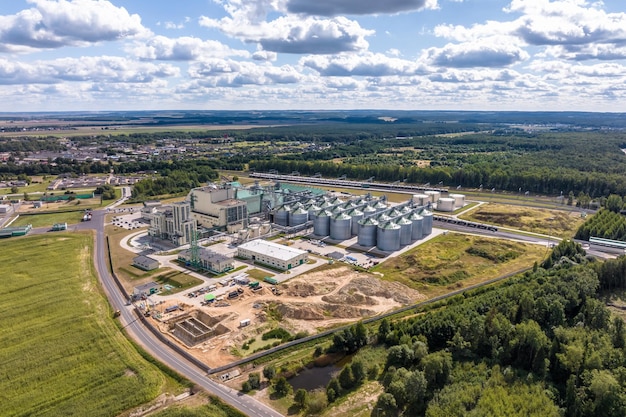 Luftbild auf Reihen von Agro-Silos Getreideaufzug mit Saatgut-Reinigungslinie in einer riesigen Agroprocessing-Produktionsanlage zur Verarbeitung von Trocknungsreinigung und Lagerung von landwirtschaftlichen Produkten