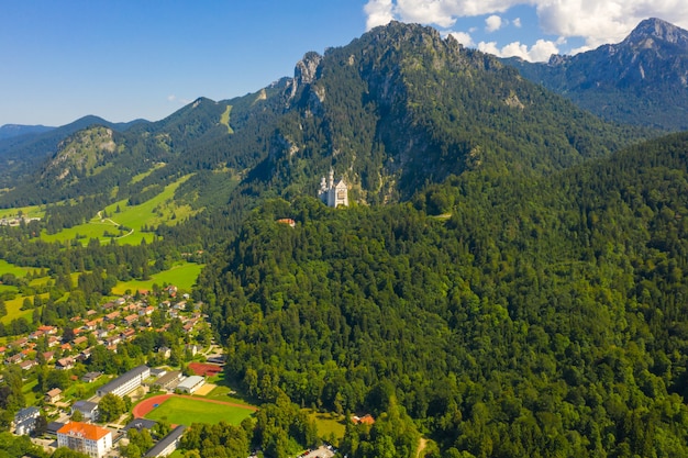 Luftbild auf Schloss Neuschwanstein Schwangau, Bayern, Deutschland. Drohnenbild der Alpenlandschaft mit Bäumen und Bergen.