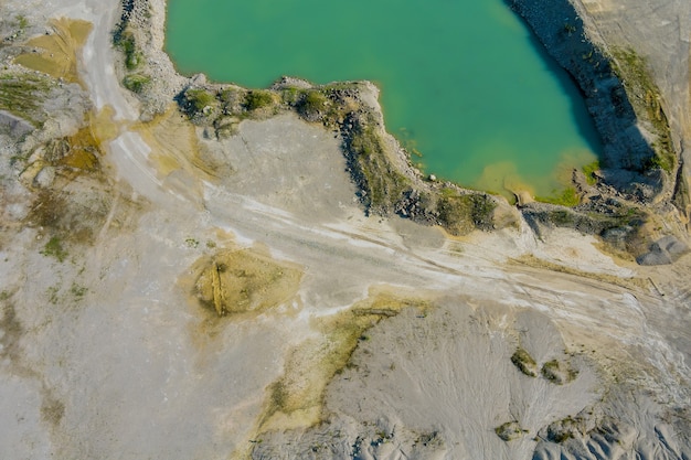 Luftbild aus einer Tongrube mit einem riesigen grünen See zur Sandgewinnung in der Granitkarriere