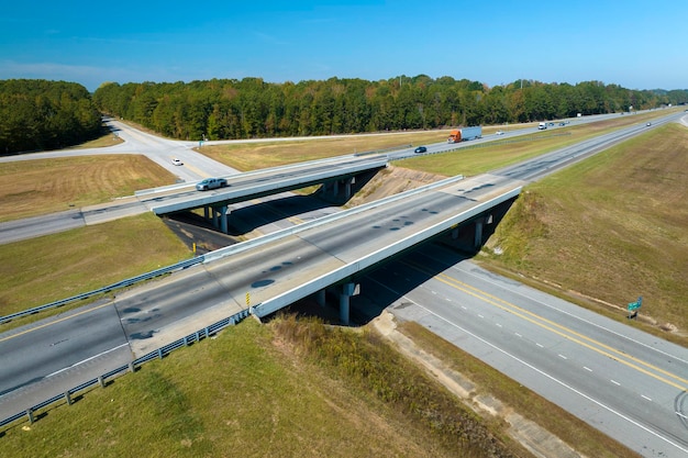 Luftbild der Autobahnüberführung mit sich schnell bewegenden Autos und Lastwagen im amerikanischen ländlichen Gebiet Zwischenstaatliche Verkehrsinfrastruktur in den USA