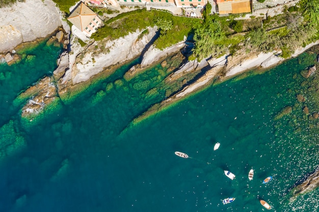Luftbild der felsigen Küste von Camogli. Boote und Yachten machten in der Nähe des Hafens mit grünem Wasser fest.