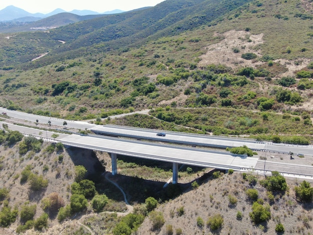 Luftbild der Straßenbrückenviaduktstützen im Tal zwischen den trockenen gelben Hügeln