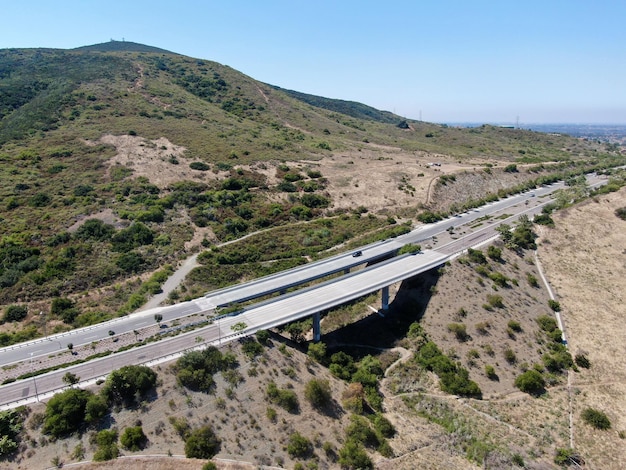 Luftbild der Straßenbrückenviaduktstützen im Tal zwischen den trockenen gelben Hügeln