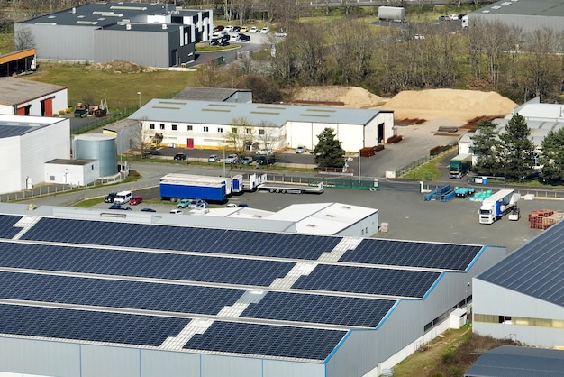 Luftbild des Solarkraftwerks mit blauen Photovoltaikmodulen, die auf dem Dach des Industriegebäudes zur Erzeugung von grünem Ökostrom montiert sind Produktion eines nachhaltigen Energiekonzepts