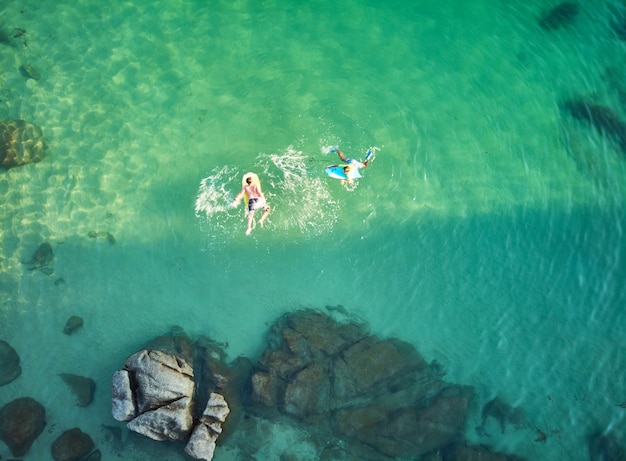 Luftbild Glückliche lächelnde Kinder mit Bodyboard. Kinder haben Spaß im Freien. Konzept der Sommerferien und des gesunden Lebensstils.