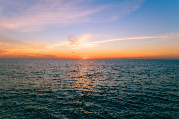 Luftbild Schöner Blick auf den Sonnenuntergang über der Meeresoberfläche schöne Welle Erstaunlicher leichter Sonnenuntergang oder Sonnenaufgang über dem Meeresstrand mit Welle am Sandstrand.