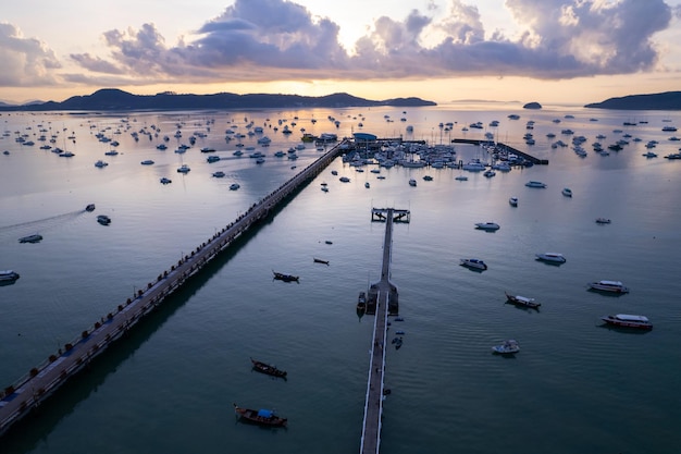 Luftbild Top-down-Drohne Aufnahme von Yacht- und Segelboot-Parkplätzen in der Marina in Chalong Bay Transport- und Reisehintergrundkonzept Schönes Meer mit Bergsonnenaufgang Himmel Wolken Sonnenuntergang Hintergrund