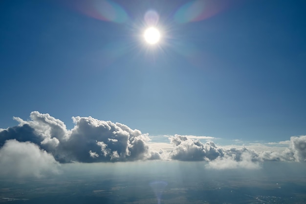 Luftbild vom Flugzeugfenster in großer Höhe der Erde, bedeckt mit weißen, geschwollenen Kumuluswolken