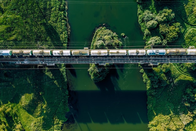 Luftbild von Eisenbahnschienen und Güterzug über den Fluss