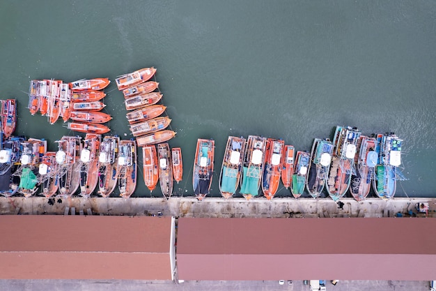 Luftbild von oben auf die vielen Fischerboote mit großem Fischereihafen am Pier in Phuket Thailand Hochwinkelansicht