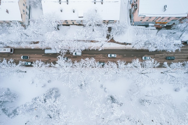 Luftbild von oben nach unten auf die schneebedeckten Straßenlandschaften der Stadt im Winter