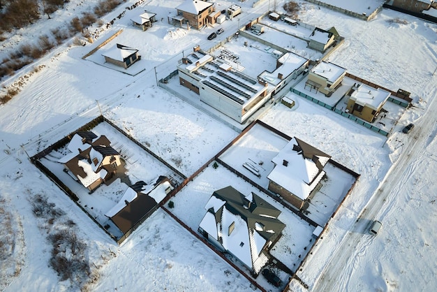 Luftbild von Wohnhäusern mit schneebedeckten Dächern im ländlichen Vorortgebiet im Winter