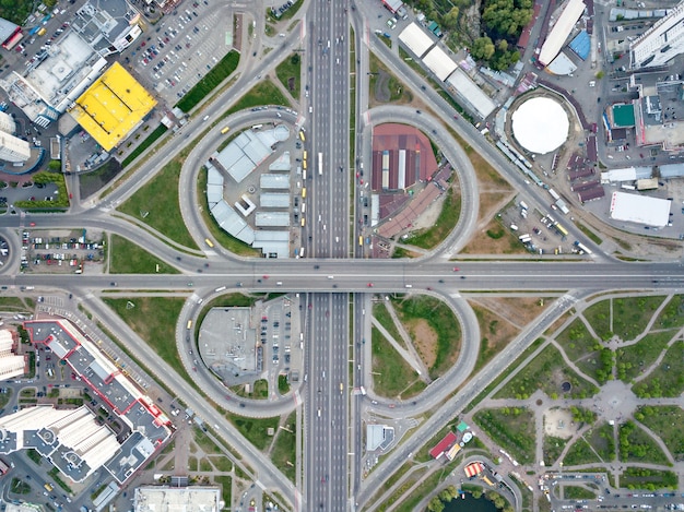 Luftbildstadt Kiew, eine moderne Straßenkreuzung mit Autos, Hochhäusern, Einkaufszentren mit Parkplätzen und Grünflächen, Bezirk Poznyaki, Ukraine. Foto von der Drohne