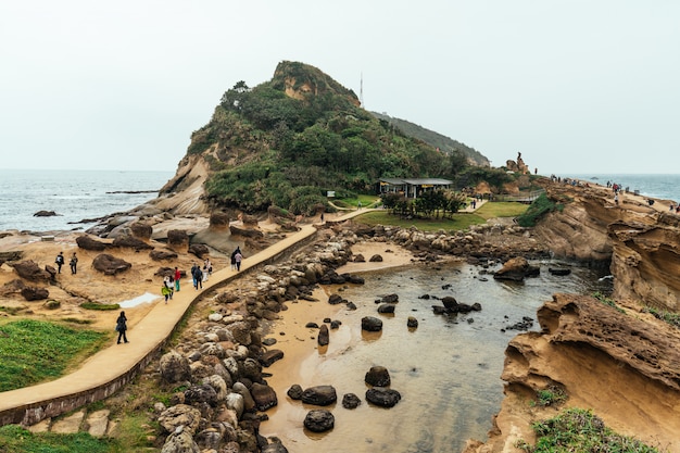 Luftbildvielfalt von Touristen, die im Yehliu Geopark, einem Kap an der Nordküste von Taiwan gehen. Eine Landschaft aus Waben- und Pilzfelsen, die vom Meer erodiert wurde.