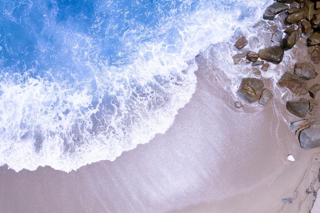 Luftbildwellen, die auf Sand des Strandes und weicher Wellenhintergrund abstürzenDraufsicht