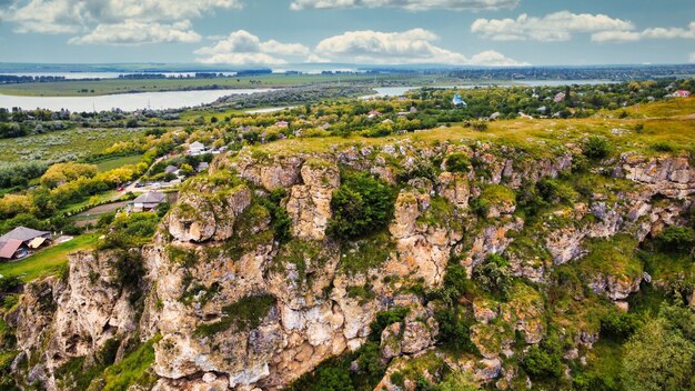 Luftdrohnenansicht der Natur im Moldova Canyon mit Dorf in der Nähe des grünen schwimmenden Flusses