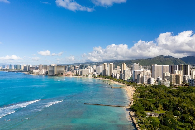 Luftdrohnenansicht der Strandpromenade von Waikiki mit Honolulu im Hintergrund