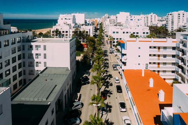 Luftdrohnenansicht der von Palmen gesäumten Straße in der portugiesischen Touristenstadt Quarteira Algarve Portugal