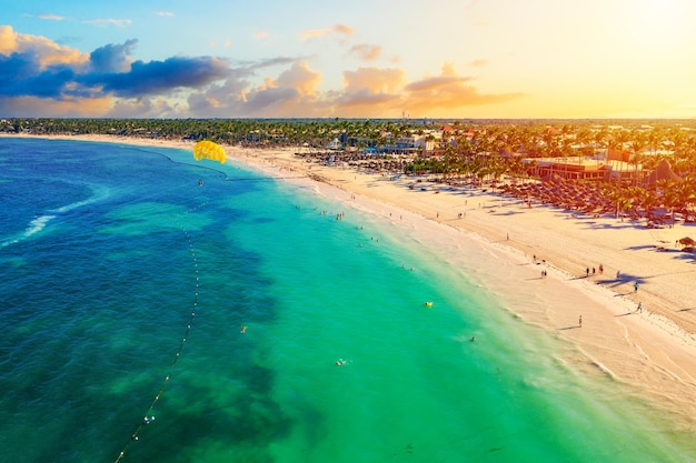 Luftdrohnenansicht des wunderschönen karibischen tropischen Strandes mit Palmen und Parasailing-Ballon bei Sonnenuntergang. Bavaro, Punta Cana, Dominikanische Republik. Urlaub-Hintergrund.