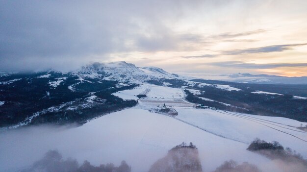 Luftgebirgswinterlandschaft. Fantastische Morgenwolken, die durch Sonnenlicht leuchten.