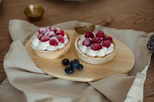 Luftige Kuchen mit Himbeeren auf einem Holztablett auf dem Tisch