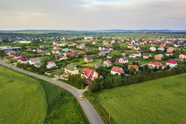 Luftlandschaft einer kleinen Stadt oder eines Dorfes mit Reihen von Wohnhäusern und grünen Bäumen.