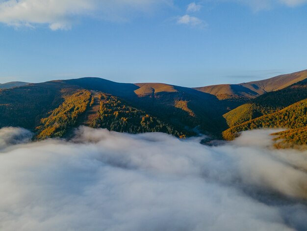 Luftlandschaftsansicht der Herbstkarpaten sonniger Tag Kopienraum weiße Wolken unter