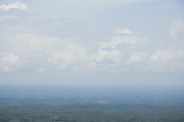 Luftlandschaftsansicht mit einer Drohne von Wiese und bewölktem Himmelshorizont Schöne natürliche Aussicht auf grüne Felder und Himmel Nebelwetter-Drohne Aufnahme eines hügeligen Dschungelgebiets und Himmelshorizonts