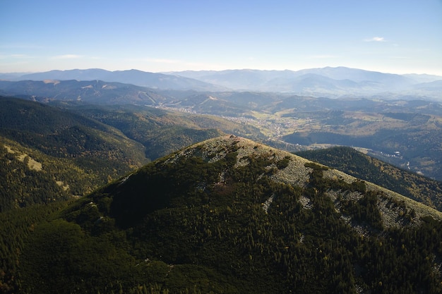 Luftlandschaftsblick auf hohe Gipfel mit dunklen Kiefernwaldbäumen in wilden Bergen