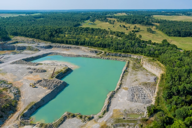 Luftpanoramablick im tagebausteinabbau in der schlucht mit tiefgrünem see